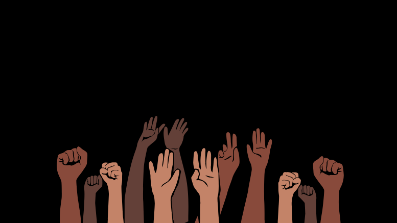 A group of diverse hands in different skin tones is raised against a black background, symbolizing unity and resistance. In a powerful stance against racism, some hands are fists while others are open, inviting dialogue and meaningful talk.