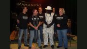 On stage, a group of musicians gathers, one dressed in white with a matching hat, while others sport black "Mamadou" shirts. As musical instruments set the backdrop, it feels as vibrant and engaging as the adult programs announced by The Milton Public Library for February 2025.