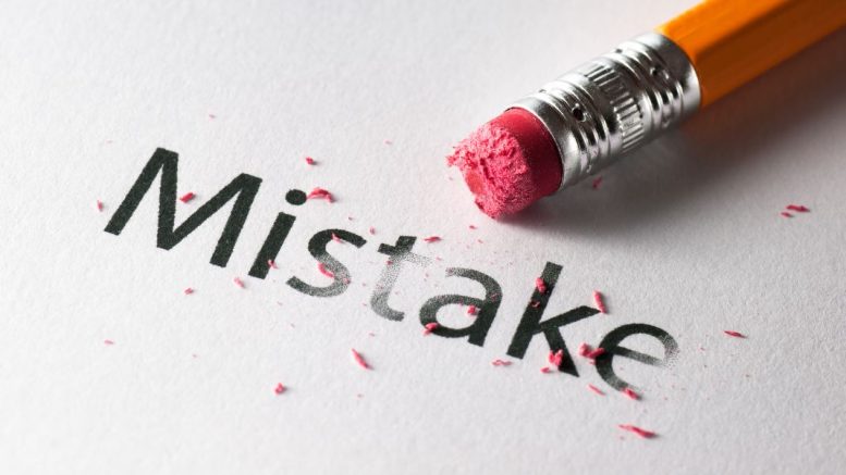 A pencil eraser, driven by the passion of a small business aiming for perfection, is carefully erasing the word "Mistake" on white paper, leaving behind a trail of eraser shavings.